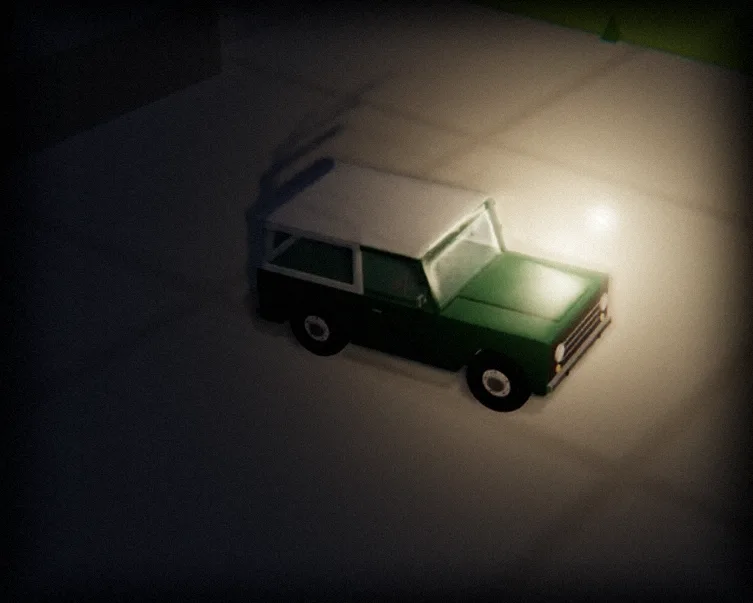 The green Bronco from Bronco Park in a dark room, lit from one side by a lamp that follows the pointer.
